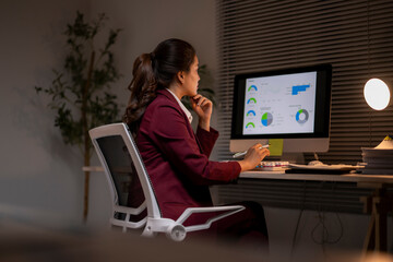 Businesswoman analyzing financial data working late in office