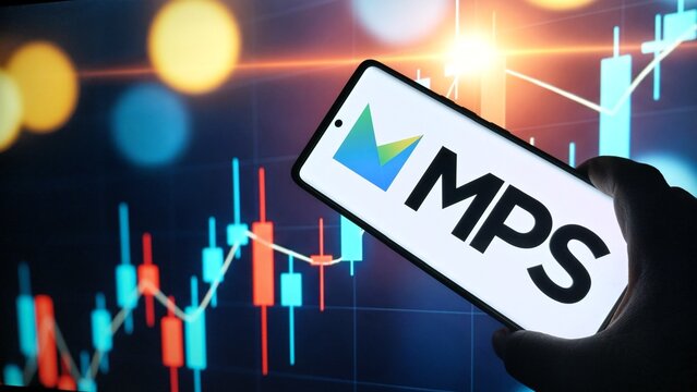 Hand holding smartphone with MPS logo on screen in front of stock market graph