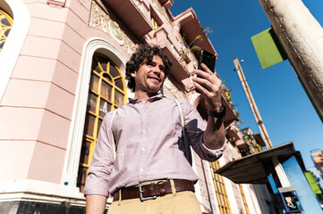 Traveler checking smartphone enjoying colonial neighborhood