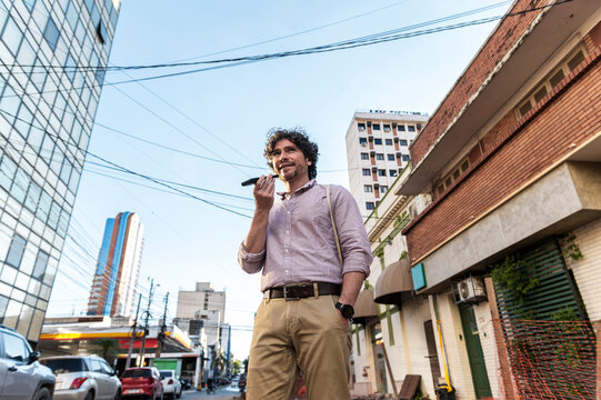 Traveler recording voice message in modern cityscape