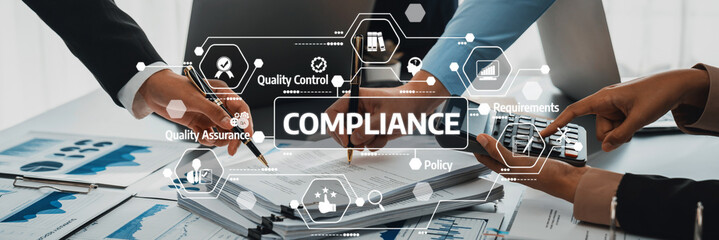 A close-up of diverse hands collaborating over compliance documents in a modern office environment, showcasing graphs and charts, symbolizing teamwork and quality assurance. Amity