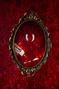 Monster vampire brushing fangs in mirror