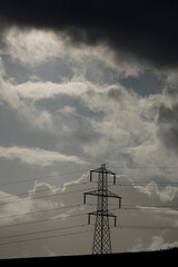 Electric power towers suppling cities and home throughout the world with electricity and Infrastructure with dramatic clouds and sky background