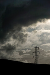 Electric power towers suppling cities and home throughout the world with electricity and Infrastructure with dramatic clouds and sky background