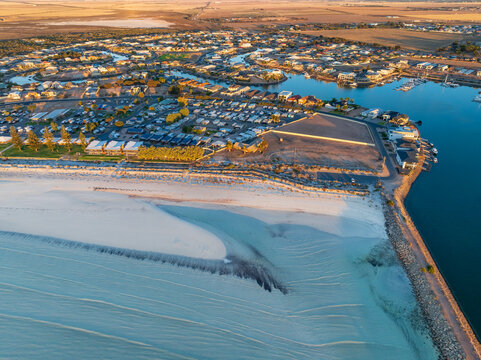 White sandy beach in front a coastal tourist park and waterfront feal 