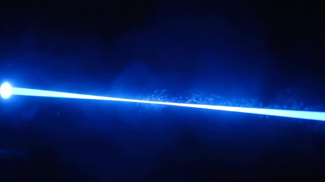 Blue Laser Beam in Dark Environment - This video shows a bright blue laser beam cutting through a dark background.