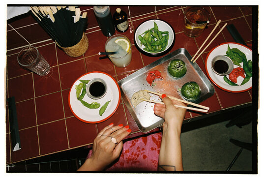 Top view of woman picking final dumpling during shared meal