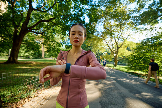 Sportswoman monitors her pace using her watch