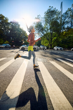 Sportswoman sprints across the street