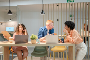 Coworkers collaborating and discussing project in modern office