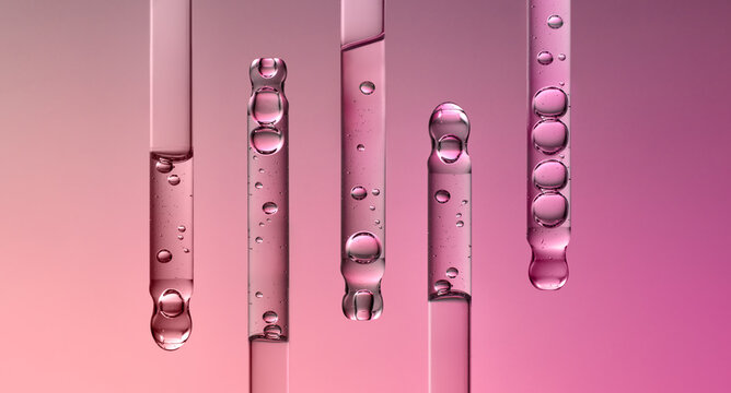Glass pipettes with liquid on gradient pink and purple background.