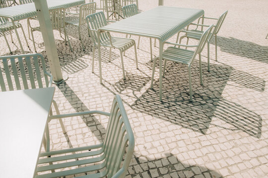 Furniture casting shadows across patterned cobblestone