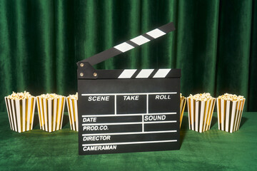 Film Clapperboard with Popcorn Boxes and Green Curtain