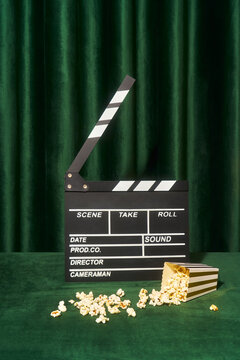 Film Clapperboard with Spilled Popcorn on Green Surface