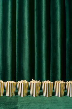 Row of Popcorn Boxes in Front of Green Curtain
