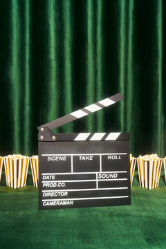Film Clapperboard and Popcorn Boxes on Green Stage
