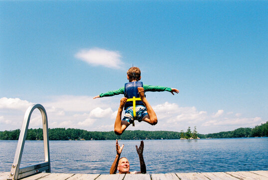 Summer in Maine: Boy jumps into lake off a dock