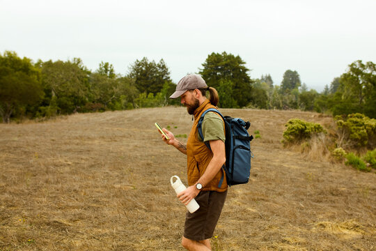 Hiker utilizes mobile phone outdoors