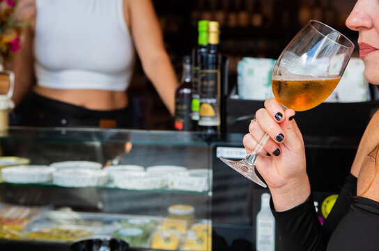 Anonumous woman drinks a glass of white wine