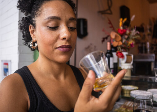 Young woman smelling a glass of olive oil
