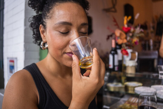 Young woman smelling a glass of olive oil