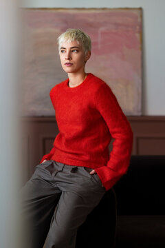 Stylish Short-Haired Woman In Red Sweater Relaxing On Sofa