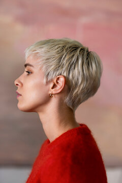 Side Profile Of A Woman With Short Platinum Hair In Red Sweater