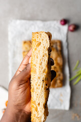 overhead view of sliced onion and scallion focaccia texture, top view of airy bubbly onion focaccia on a cement countertop, close up view on open crumb texture of bread