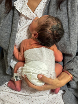 Newborn Baby Wearing Diaper Held Against Woman&acirc;s Chest
