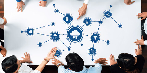 A diverse group of professionals collaborates around a table focused on cloud computing concepts, with wireless technology icons illustrating innovative ideas and strategies. Amity