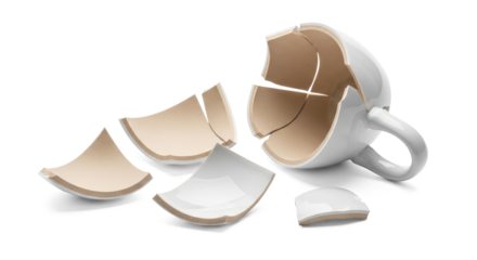 A broken white ceramic coffee mug with pieces scattered around.