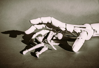 Large hand holds smaller figure artfully