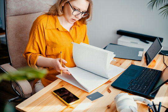 Freelance tax advisor woman analyzing paperwork at home office. Remote financial consulting and professional lifestyle.