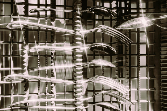 Forks and spoons glisten in bright light