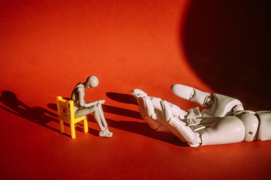 Small figure on chair reaching for a large hand