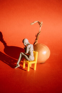 Thoughtful figure sitting on a yellow chair