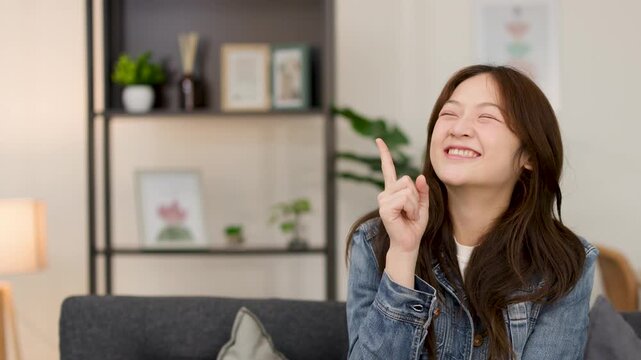 Excited Young Woman Gesturing Idea on Living Room Sofa