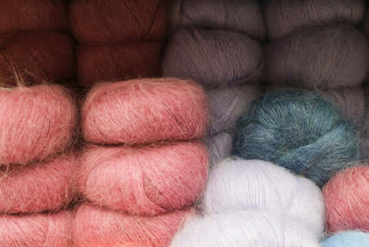 Soft and colorful yarn balls arranged neatly on display in a store