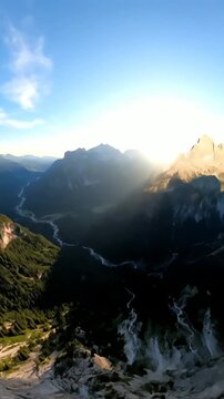 日没時の巨大な山頂の崖の近くでの FPV ドローン ダイビング、​​ドラマチックな岩だらけの風景の自然アドベンチャー。