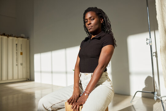 Model posing confidently in a studio with natural light
