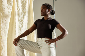 Model poses confidently in studio with elegant backdrop