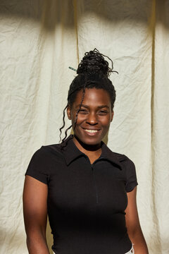 Smiling woman poses against a simple backdrop
