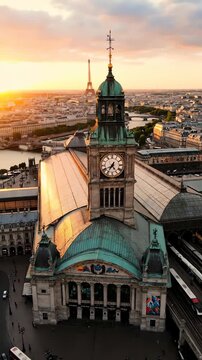 夕暮れ時のパリ・リヨン駅の素晴らしい空中写真。遠くの街並みに時計塔とエッフェル塔が映っています。