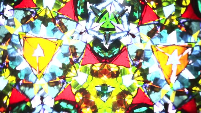 Mesmerizing rotation of a natural kaleidoscope. Vibrant shards of glass create intricate, ever-changing symmetrical patterns and colorful abstract mosaics in a fluid, hypnotic motion.