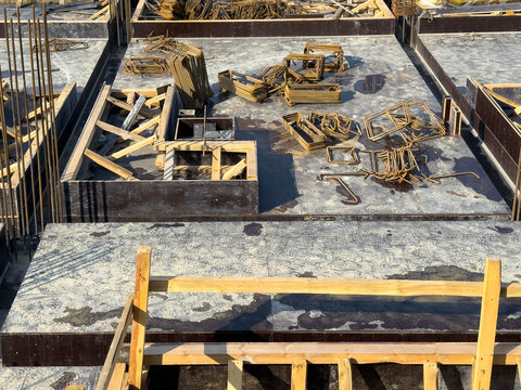 Rebar Stirrups, Formwork, and Wooden Supports on Construction Floor