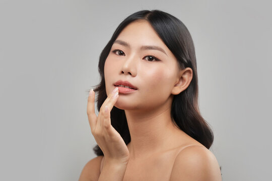 Beautiful Asian woman touching her lips, soft focus