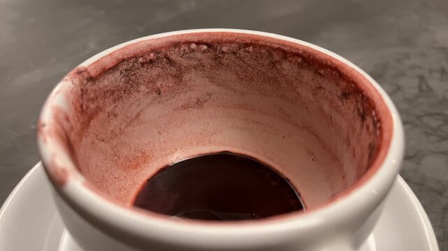 close up view of empty white cup or mug with tea spoon. hot red velvet. stainless steel. ceramic. isolated on grey or gray table background. iron. light, lights, lamp, lamps. night. cafe,  coffee shop
