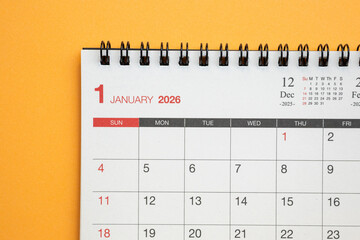 Close up of January 2026 desk calendar page on vibrant orange background for business planning and new year goals