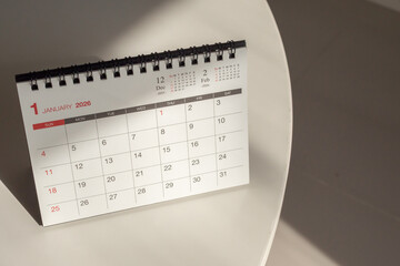 desk calendar showing January 2026 page on white table background for business organization