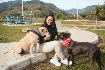 Woman feeding dogs treats in a park